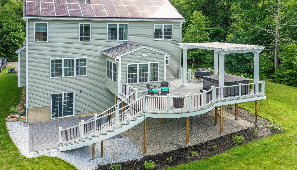 Hopkinton, NH Professional Building Services Mega Curved Deck & Curved Staircase with Steel Framing, Trex Pergola, and Jacuzzi Support