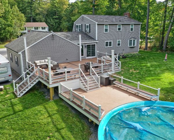 Windham, NH Professional Building Services Multi-Level Deck with Dual Staircase,  Poor Surround, and Custom Benches in Transcend Spiced Rum, Transcend White Railing and Black Round Metal Balusters