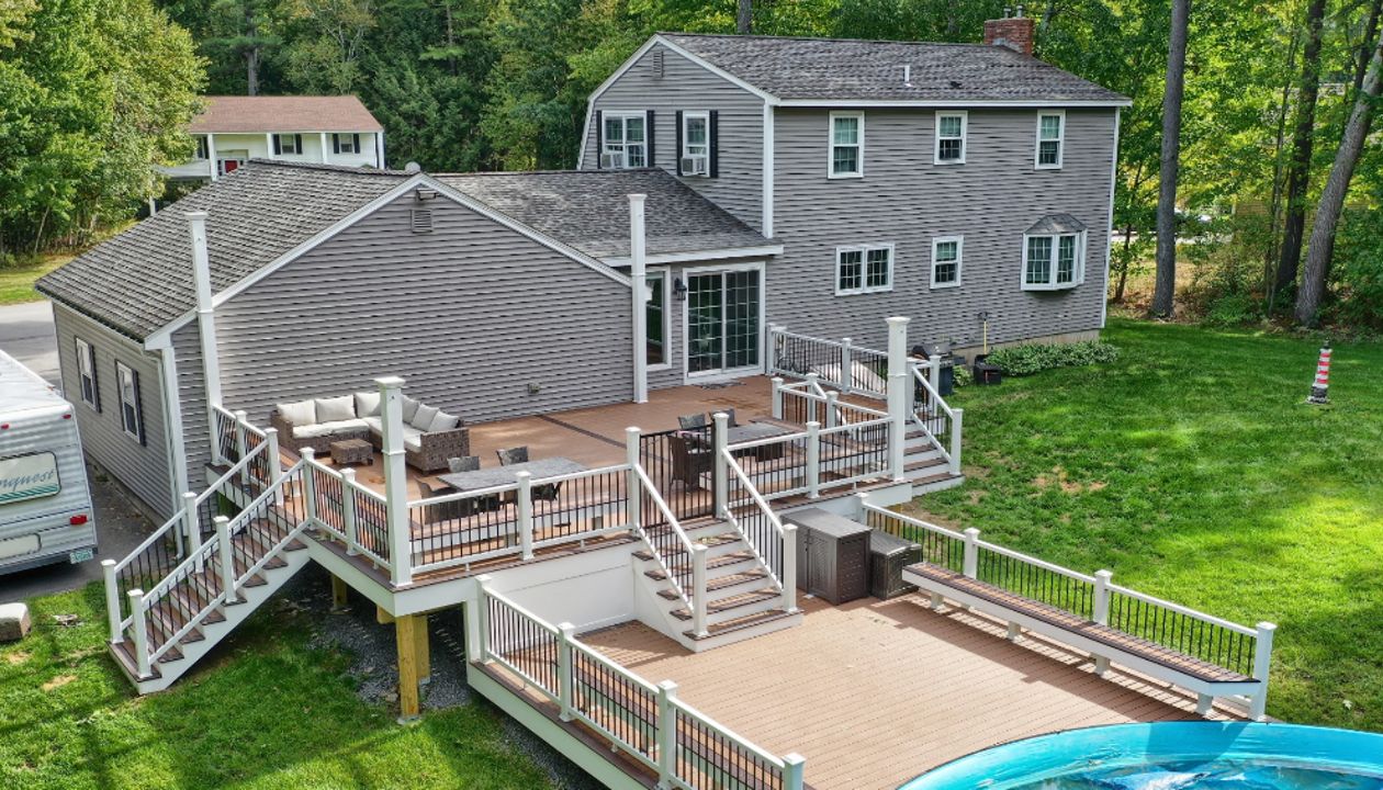 Windham, NH Professional Building Services Multi-Level Deck with Dual Staircase,  Poor Surround, and Custom Benches in Transcend Spiced Rum, Transcend White Railing and Black Round Metal Balusters