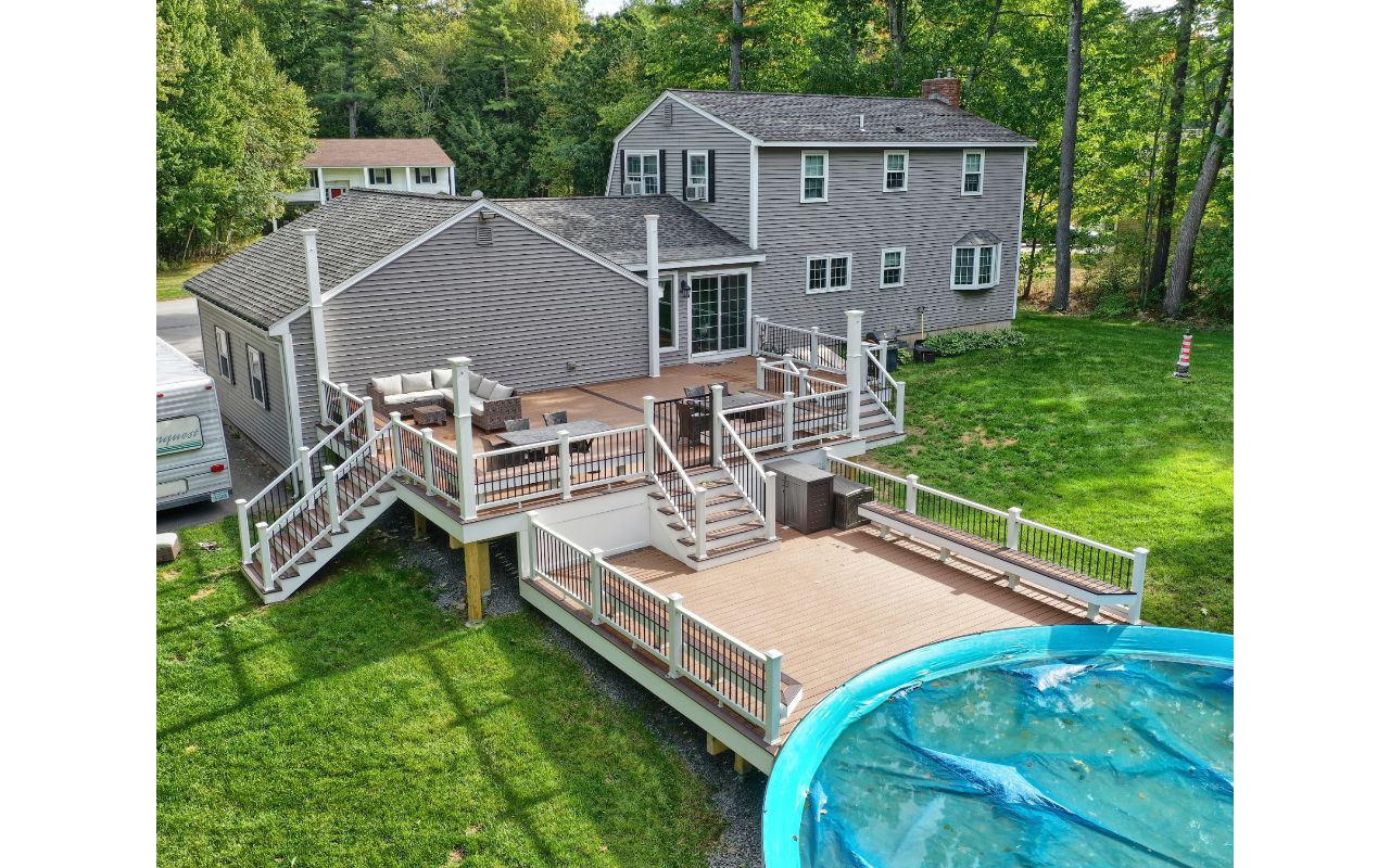 Windham, NH Professional Building Services Multi-Level Deck with Dual Staircase,  Poor Surround, and Custom Benches in Transcend Spiced Rum, Transcend White Railing and Black Round Metal Balusters