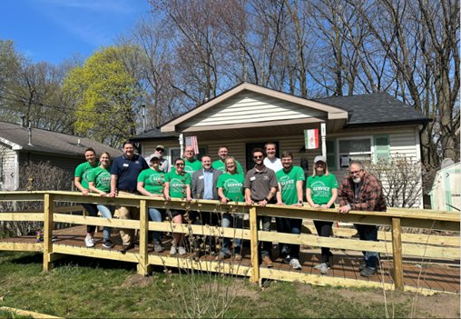 Group of volunteers take a photo during a recycling imitative for veterans.