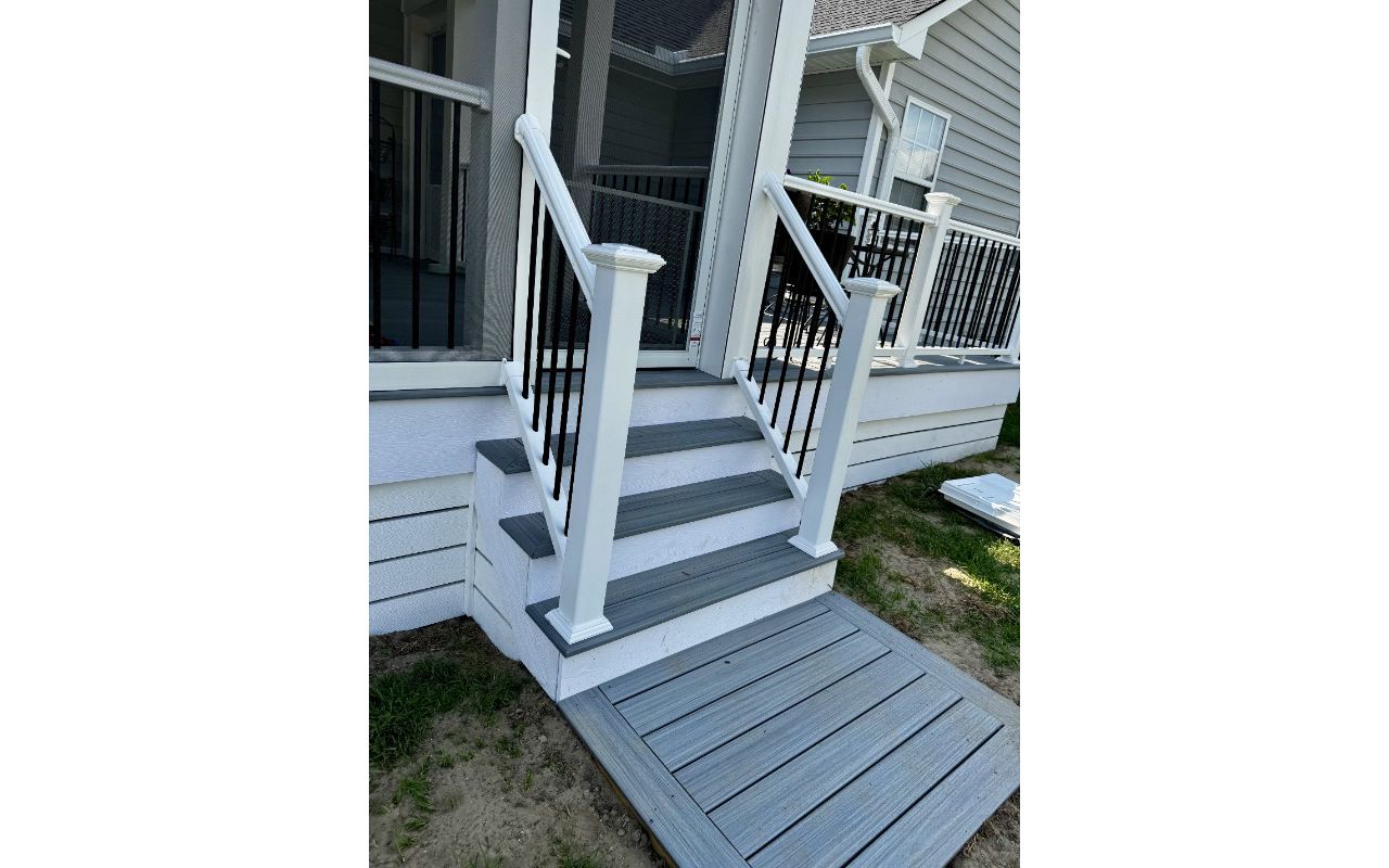 Trex Foggy Wharf composite deck landing and steps featuring crisp white PVC fascia trim. Custom deck builder in Lillington, NC.