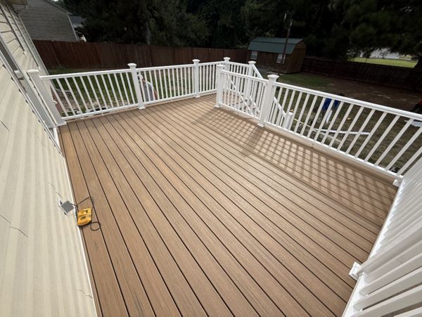 Trex Golden Hour composite deck with traditional white railings and crisp white PVC fascia trim built in Cameron, NC.