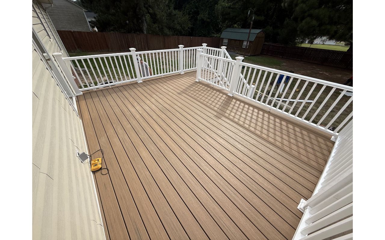 Trex Golden Hour composite deck with traditional white railings and crisp white PVC fascia trim built in Cameron, NC.