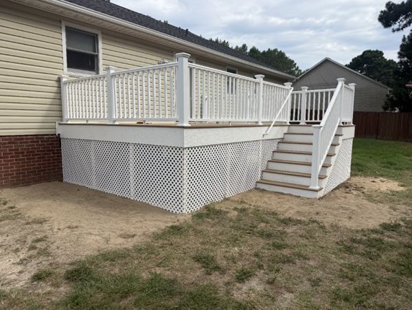 Trex Golden Hour composite deck installation with white railing and white PVC stair risers by local Cameron, NC contractor.