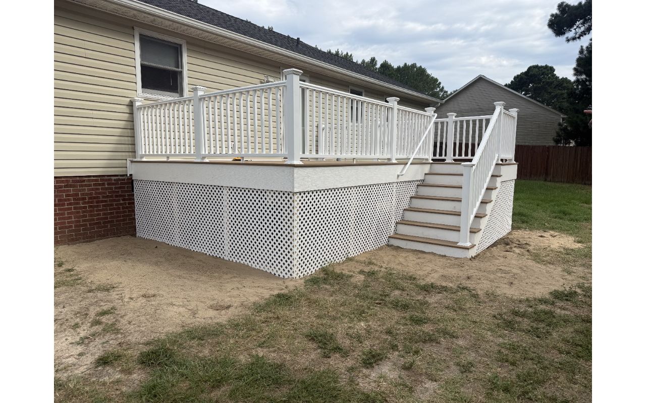 Trex Golden Hour composite deck installation with white railing and white PVC stair risers by local Cameron, NC contractor.