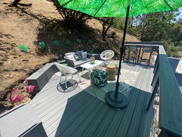 Trex Transcend hilside deck with a retaining bench and a bar in Island Mist