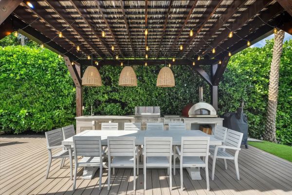 Custom-buit Trex deck with covered pergola illuminated for elegant evening gatherings
