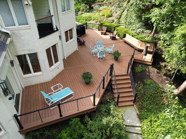 Private backyard deck with a staircase leading to lush garden surroundings.