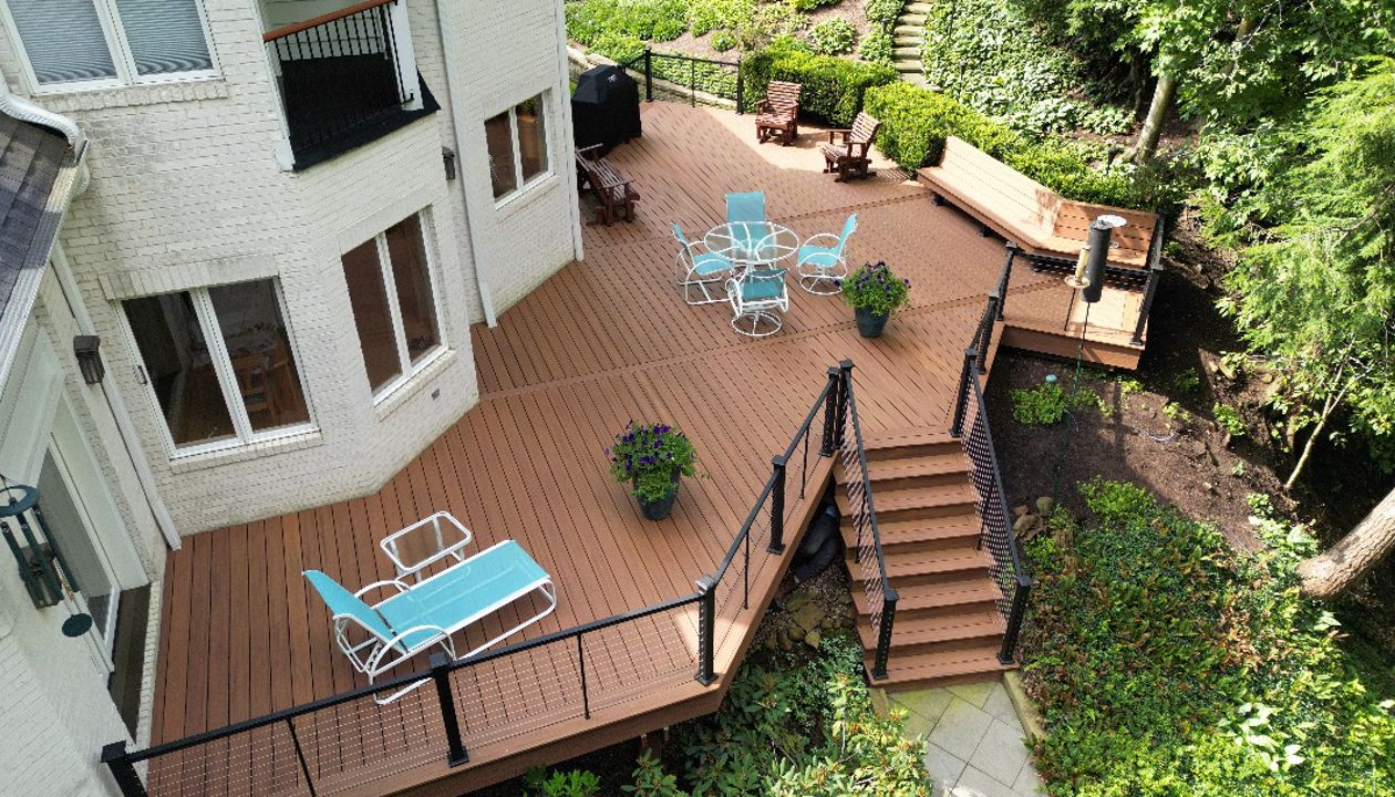 Private backyard deck with a staircase leading to lush garden surroundings.