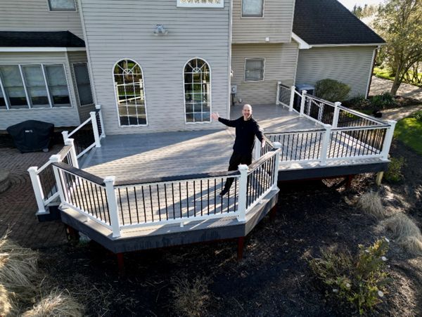 Raised deck with white railing offering a picturesque view of the backyard.