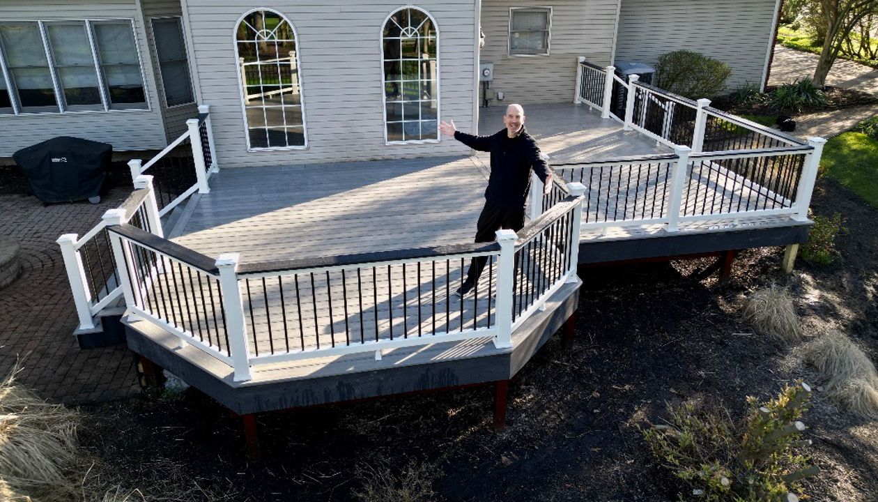 Raised deck with white railing offering a picturesque view of the backyard.