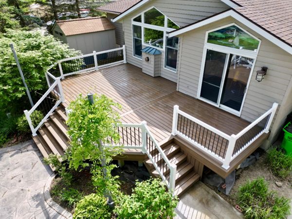 Spacious wraparound deck with modern black and white railing accents.