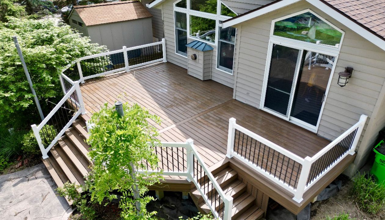 Spacious wraparound deck with modern black and white railing accents.