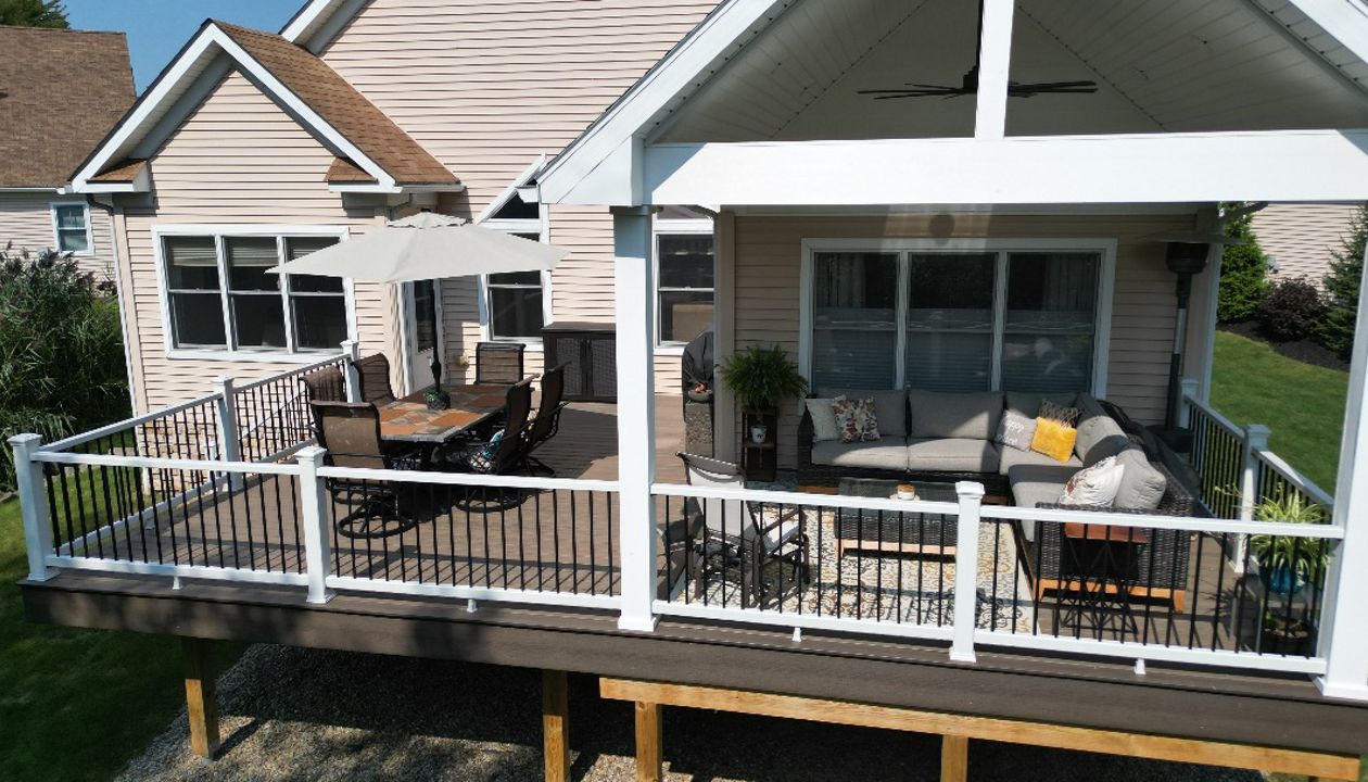 Covered deck area with stylish furnishings and ample outdoor seating.