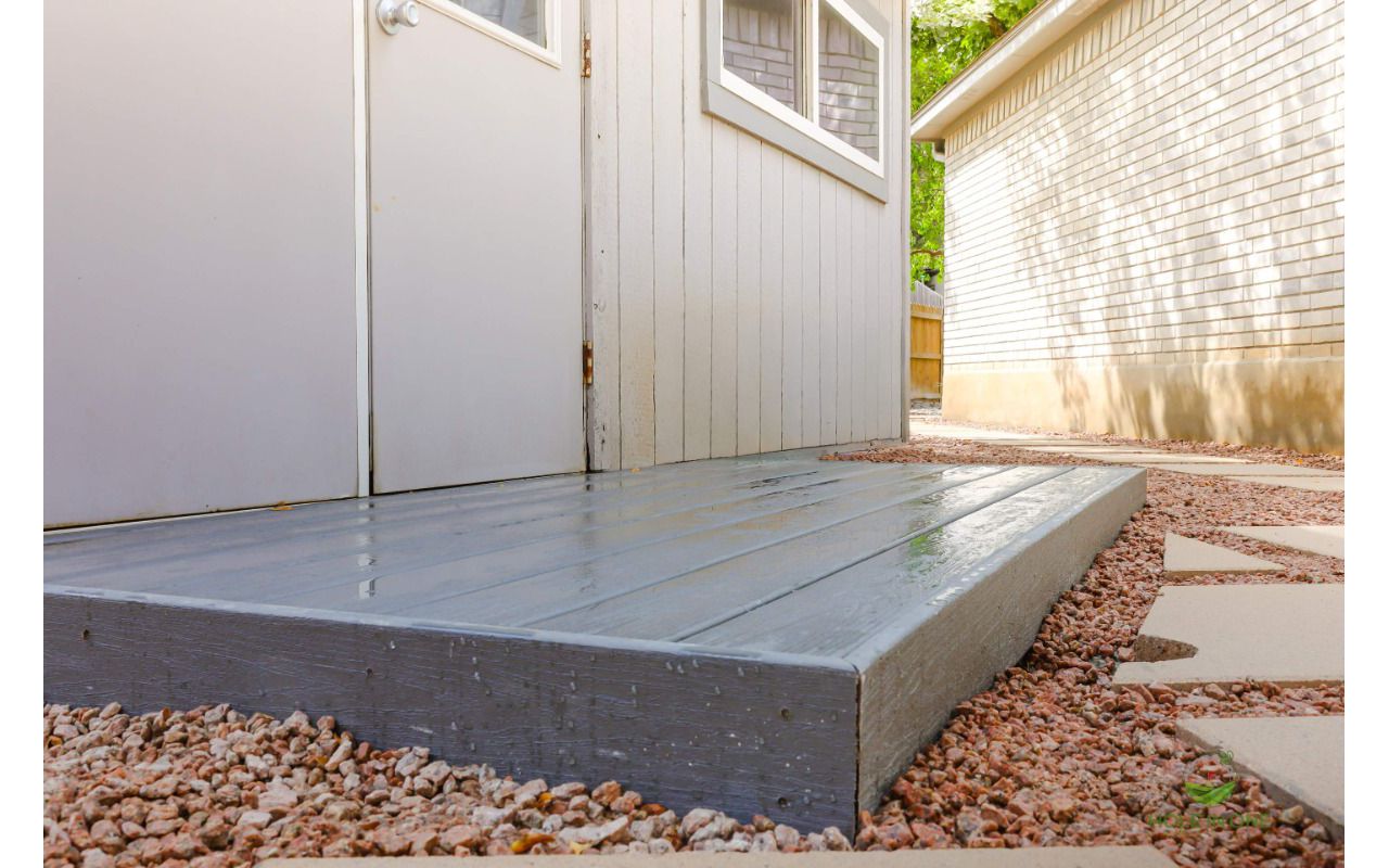 Low-profile Trex composite landing with fascia set in gravel beside a home