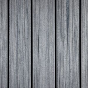 The image shows a close-up view of gray composite decking boards arranged vertically. The boards feature a realistic wood grain texture with subtle variations in tone, giving a modern and clean appearance. The setting suggests an outdoor or patio flooring application, with a neutral color palette and linear pattern. No visible text, numbers, or logos are present in the image.