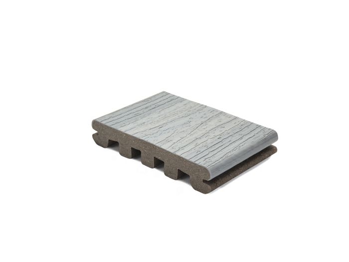 A single piece of gray composite decking board is displayed against a white background. The board features a realistic wood grain texture on the surface and a hollow core structure underneath. The sample is shown at an angle to highlight both the top texture and the internal design. No visible text or numbers are present on the board.