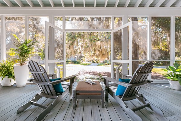 Screened in porch with decking in Trex Foggy Wharf with two Adirondack chairs looking out on the yard