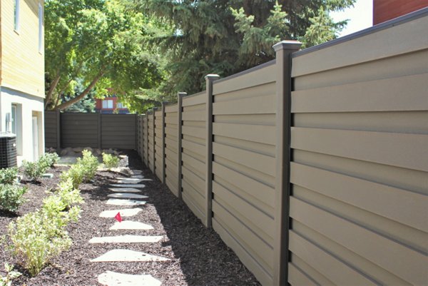 Backyard fence with a stone path in a garden.