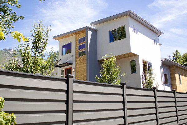 Beautiful brown Trex fence with a lawn and garden. 