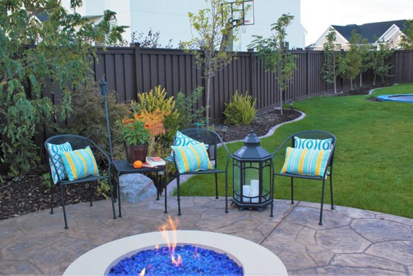 Beautiful brown Trex fence with a lawn and garden. 