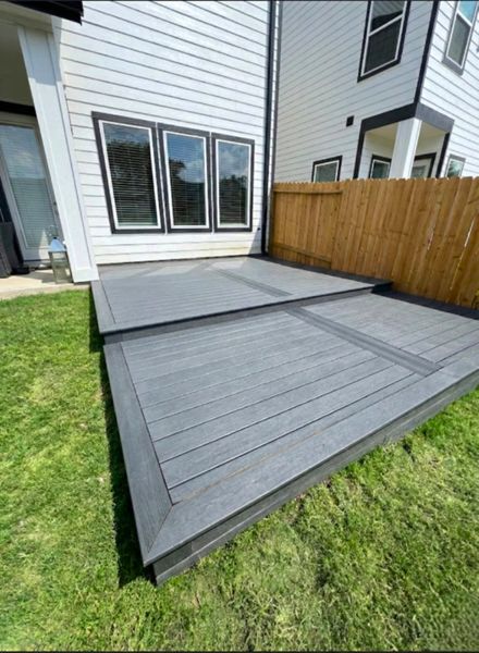 Multi-level gray composite deck in Houston, Texas. Designed to create defined outdoor zones for seating, dining, and relaxing.