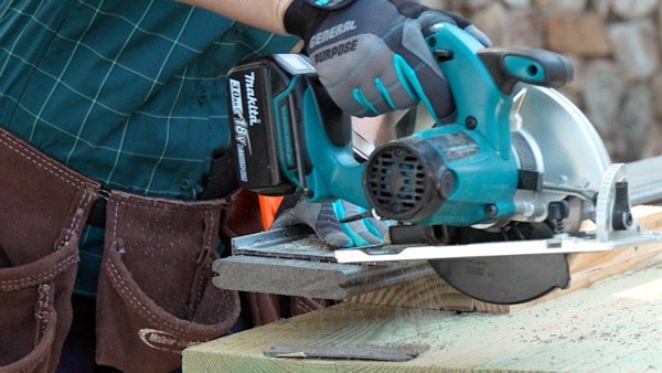 Man with circular saw cutting Trex decking for a deck build.