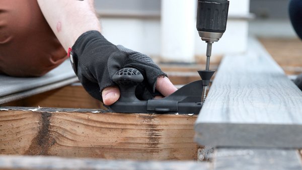 Man with circular saw cutting Trex decking for a deck build.