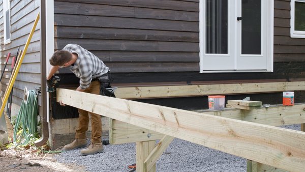 person fastening side joist