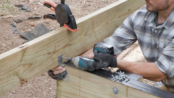 person fastening the tie to the joist
