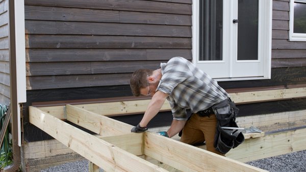 person fastening blocking to joist