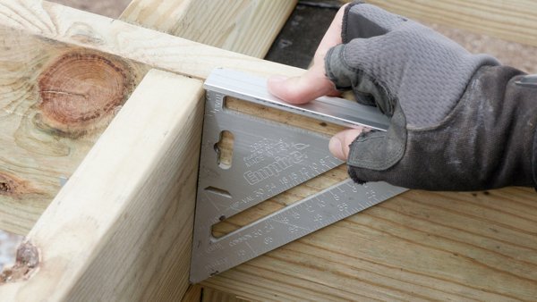 using speed square to make sure blocking is plumb