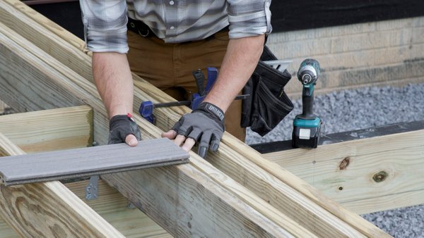 person testing the decking board alignment on the top of the breaker board