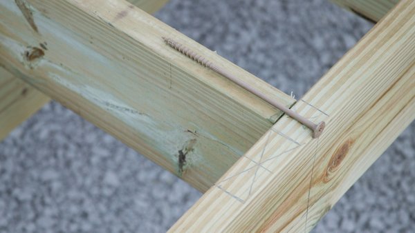 screw laying on top of joist connection to show proper depth