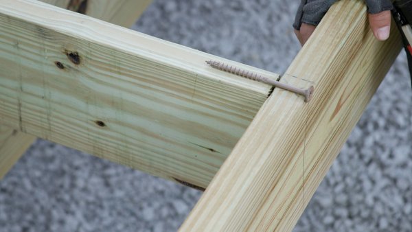 screw laying on rim joist connection to show proper depth