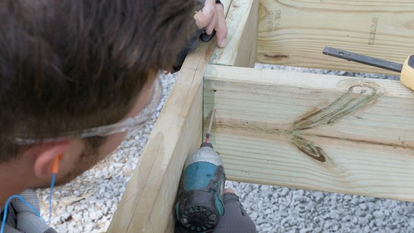 person adding screws to extra joist material in between field joists