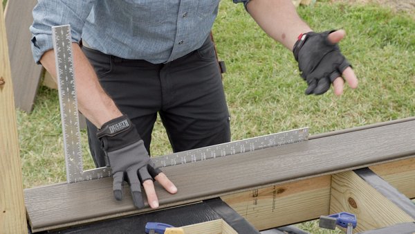 Man with circular saw cutting Trex decking for a deck build.