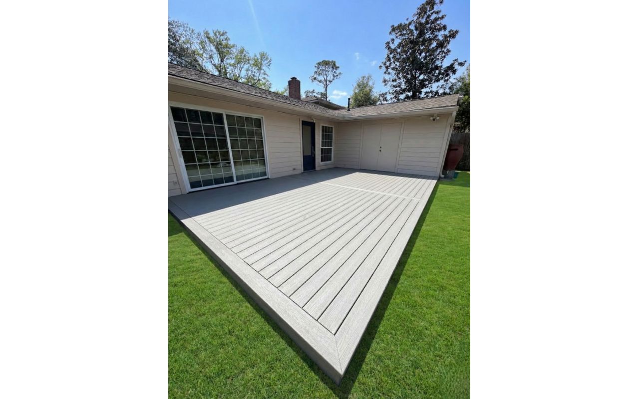 Light gray Trex composite deck, ground-level installation. Minimalist design with a clean finish, perfect for low-maintenance outdoor living.