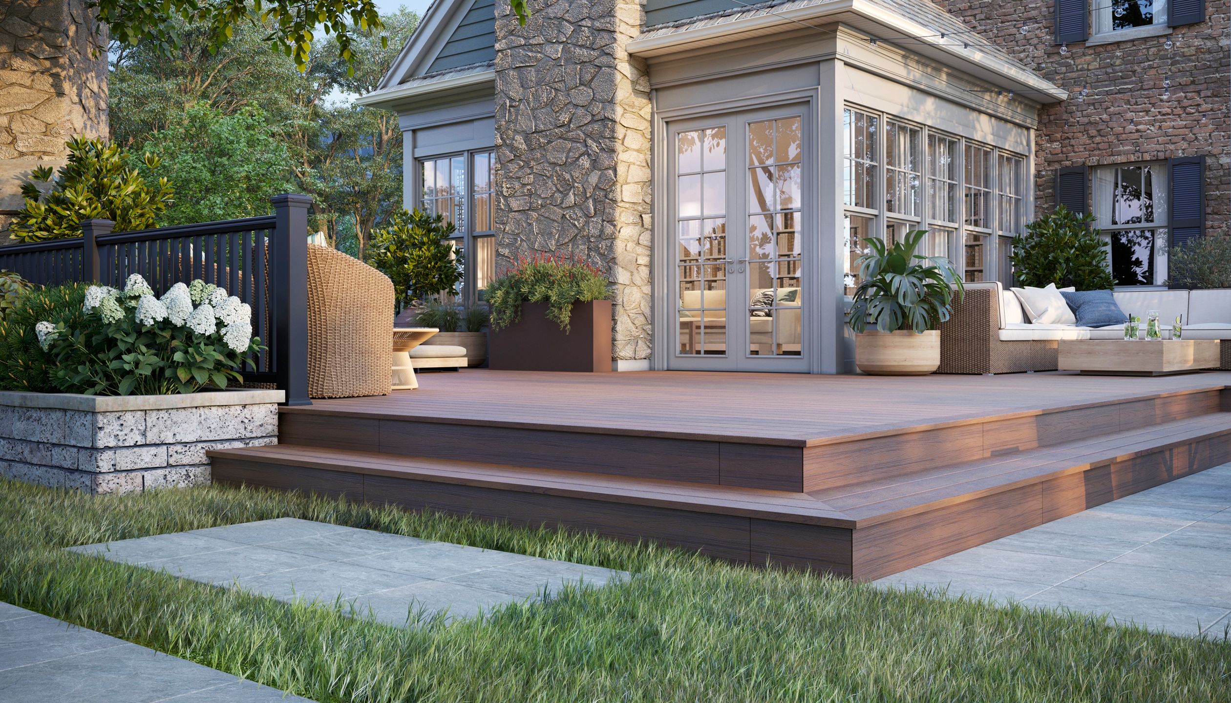 Transcend Linage decking and fascia in Hatteras, with Charcoal black railing with composite balusters and furniture in a mountain environment