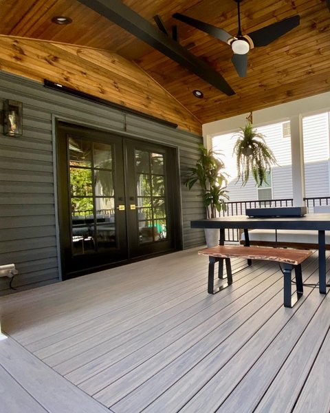 Screened in porch with decking in Trex Foggy Wharf with two Adirondack chairs looking out on the yard