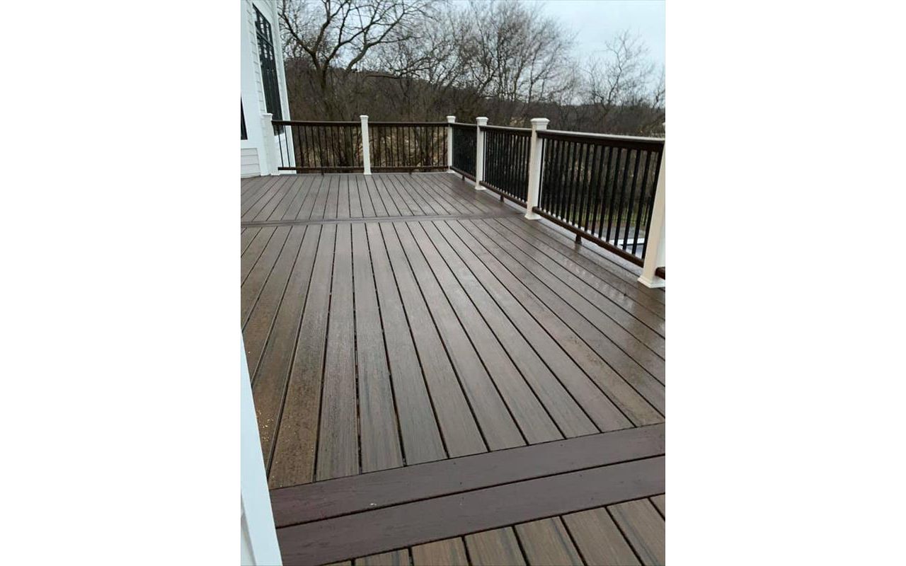 This deck features Trex transcend spice rum as the main decking and drink rail and Trex transcend vintage lantern for the picture frame and middle divider. It has Trex transcend railing that consists of white post sleeves, vintage lantern top/bottom rail.