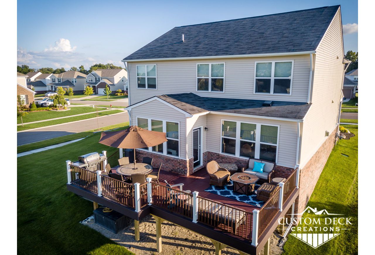 Trex Select Madeira decking and picture frame with Select Woodland Brown fascia. Railing is bronze Trex Signature aluminum railing with white Trex Transcend composite railing posts.