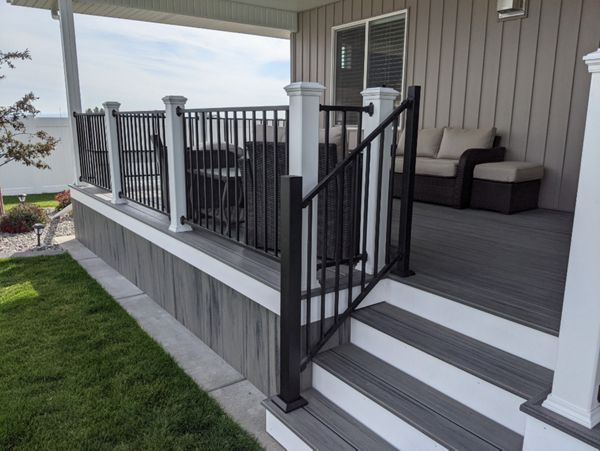 Island Mist Decking and Skirting, Black Iron Metal Rail and white Trex Posts.