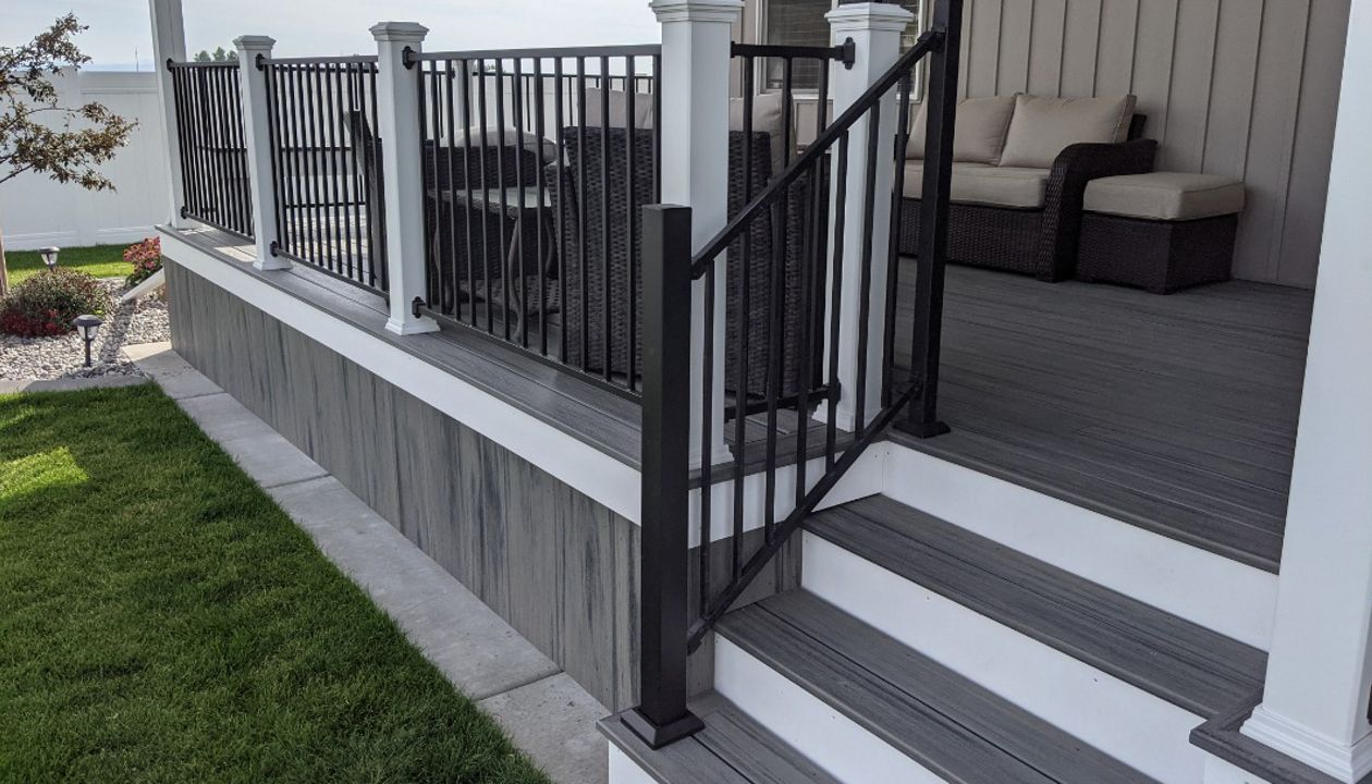 Island Mist Decking and Skirting, Black Iron Metal Rail and white Trex Posts.