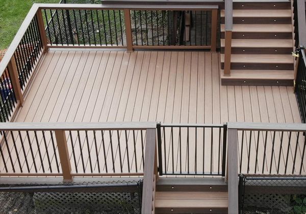 Transcend Decking in Tiki Torch with a Lava Rock picture frame, Transcend Tree House Handrail with Lava Rock Coctail Top and Black aluminum balusters,  Black aluminum gate, stair lighting, and Lava Rock fascia.