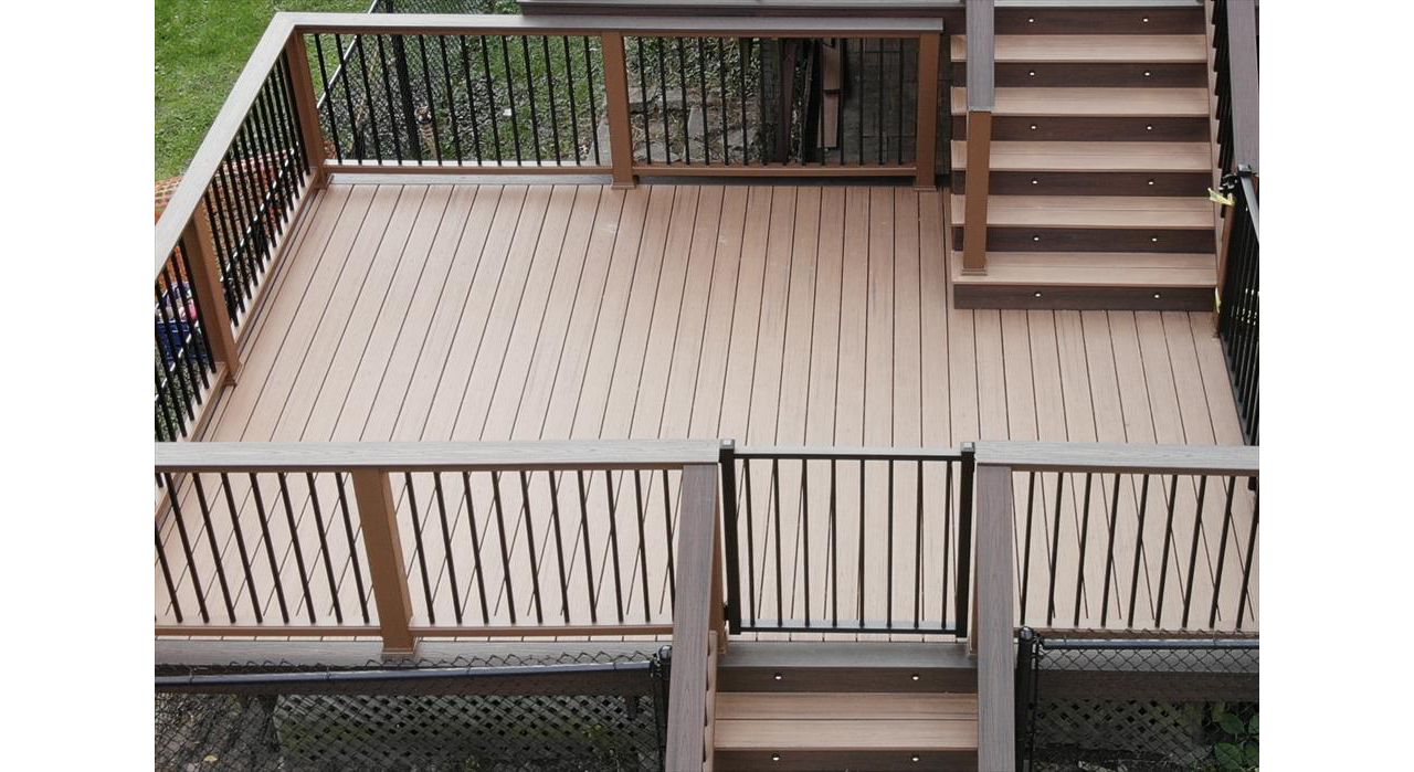 Transcend Decking in Tiki Torch with a Lava Rock picture frame, Transcend Tree House Handrail with Lava Rock Coctail Top and Black aluminum balusters,  Black aluminum gate, stair lighting, and Lava Rock fascia.