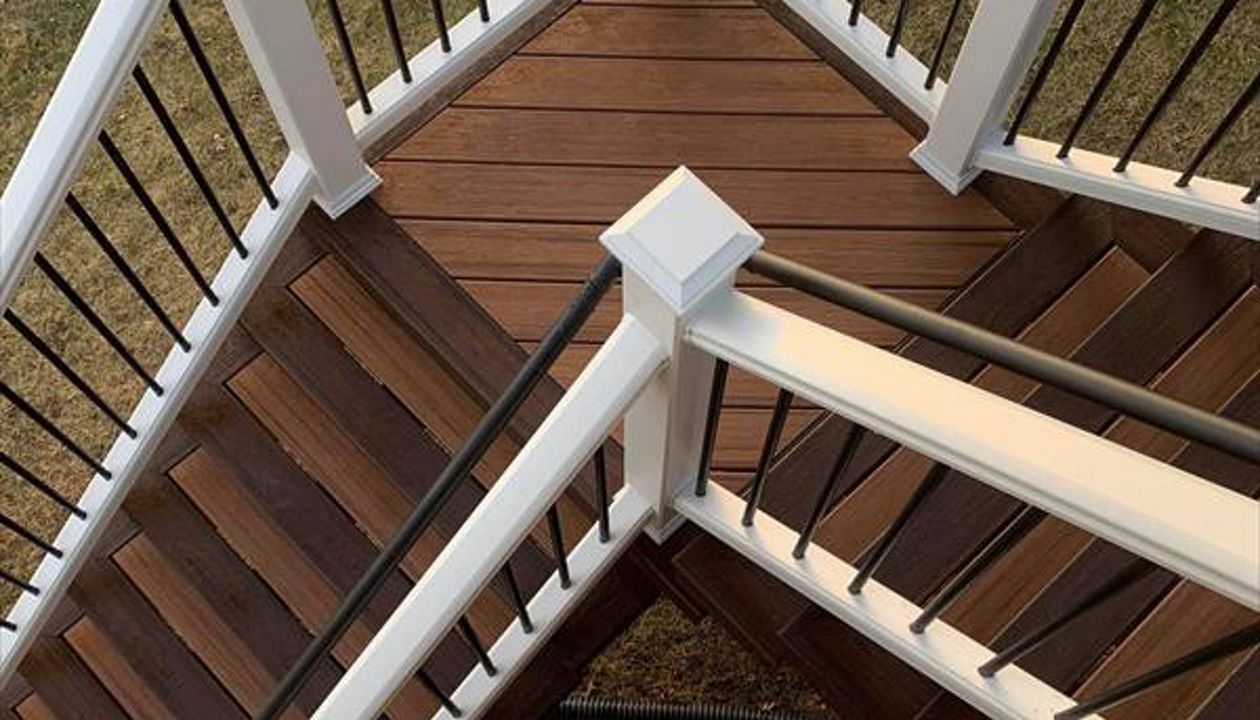 Trex Tiki Torch decking, Trex Lava Rock Border and Fascia,  Two tone stairs, White Trex Transcend Railing,  Waterford Michigan Oakland County Wright Way Contractors