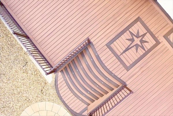 Trex Transcend Tiki Torch field with Spiced Rum boarder . Compass start inlay , custom curve steps , Signature railing . fitted at Swansea