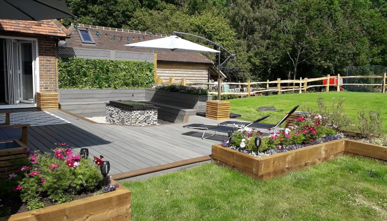 Project outline: Create and entertaining space with seats and a fire pit the customer opted for Island Mist Transcend deck plank with Toasted Sand Transcend border plank